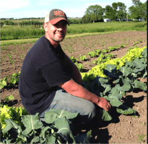 Man sitting in row of crops
