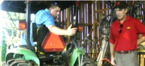 Two farmers working in a shed with a utility task vehicle (UTV).